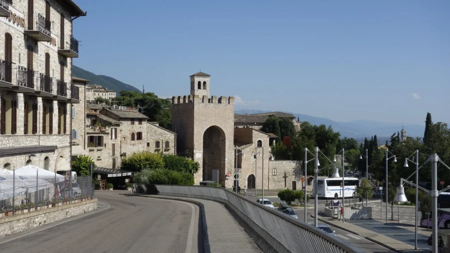 Porta San Pietro: historic medieval stone gatehouse and sunlit Italian town street.