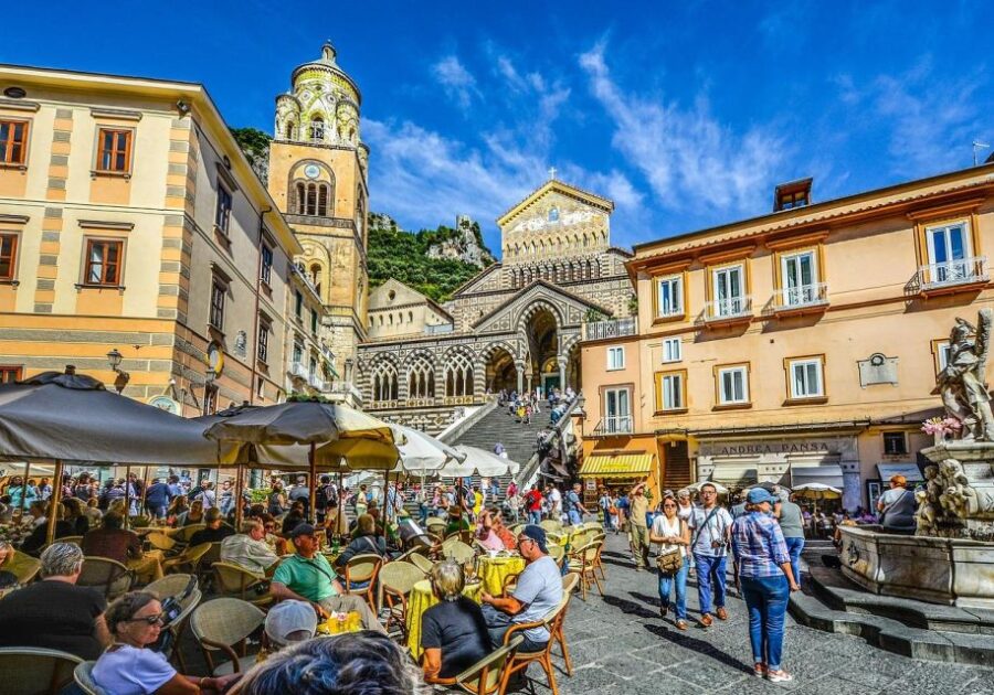 Bustling Italian square with cafes, cathedral, cobblestone streets, historic architecture, Ravello scenery.