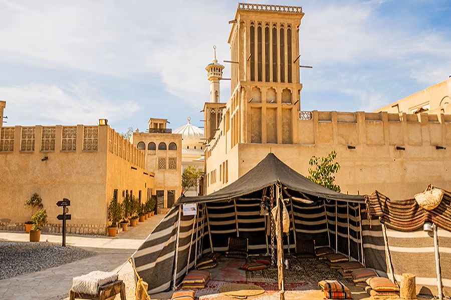 Traditional Arabic architecture with tent, wind towers, mosque; Al Fahidi Historical District.
