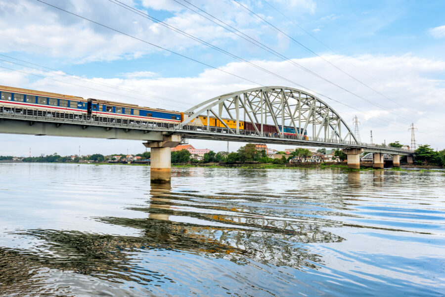 Train crosses the historic Binh Loi Bridge in Ho Chi Minh City, Vietnam, showcasing the city's blend of old and new.