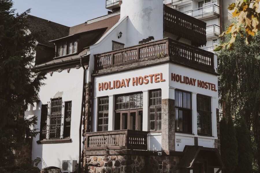Charming Holiday Hostel with modern-traditional design, lush greenery, and inviting balcony.