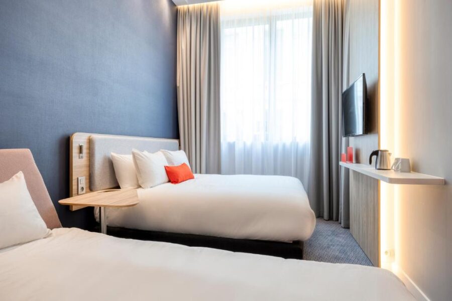 Hotel room at Holiday Inn Express Antwerp with two beds and a television, designed for comfort and relaxation.
