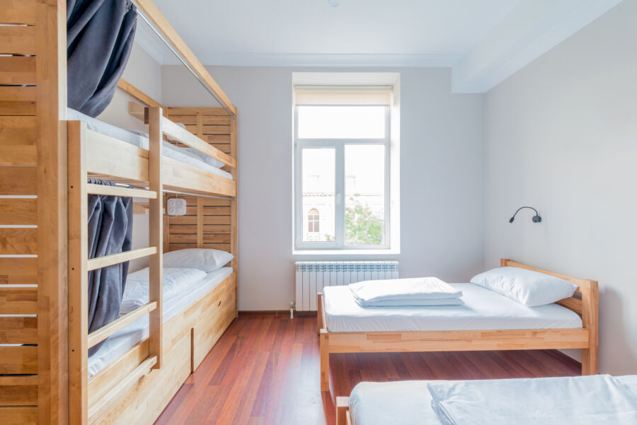 Interior view of a hostel dormitory with several beds organized in a communal living space