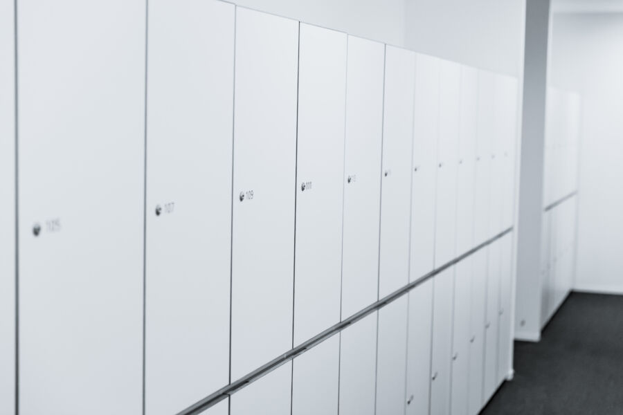 Clean, white locker room in a hostel, featuring organized lockers and a bright, inviting atmosphere
