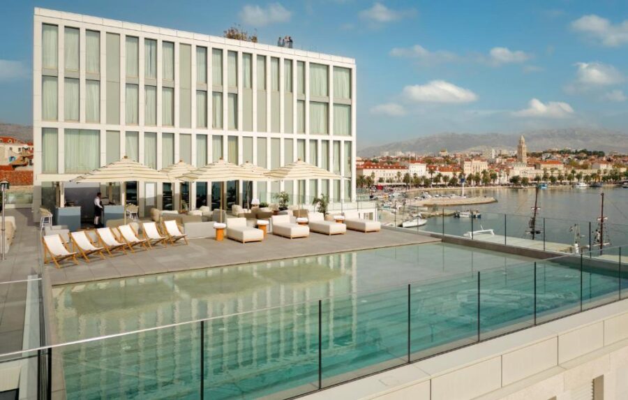 Inside Cornaro Hotel, a spacious room with a large bed and beautiful ocean views, located in Split, Croatia.
