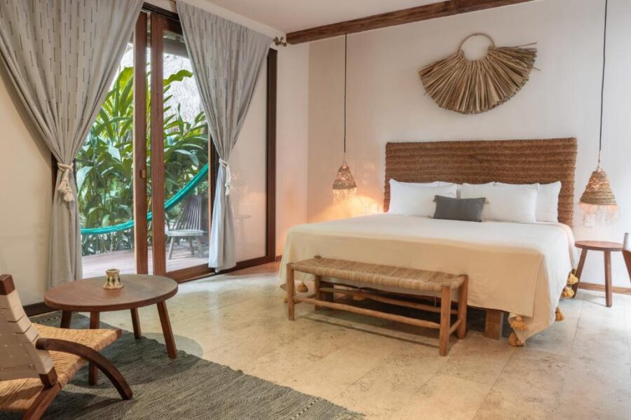 cCfeaturing a bed, chair, and large window, located at Hotel Casa Hormiga in Bacalar, Mexico.