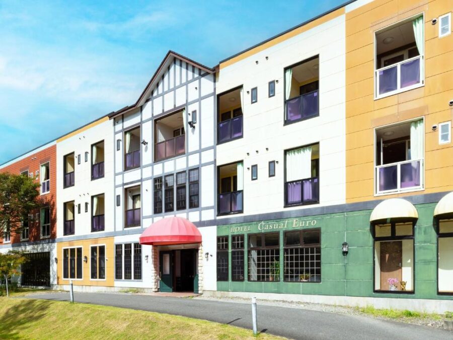 Hotel Casual Euro modern European-style hotel facade with colorful balconies, gabled roof, and entrance awning.