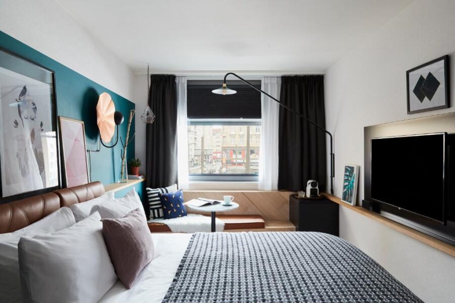 Cozy hotel room at Hotel Indigo Antwerp City Centre featuring a bed, desk, and television for a comfortable stay.

