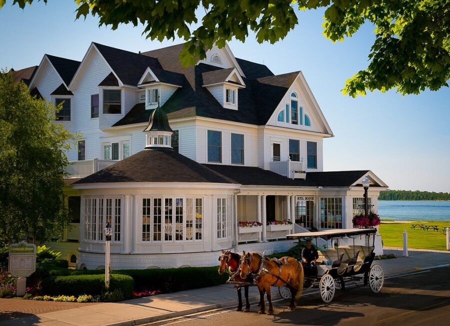 Waterfront Hotel Iroquois with Victorian architecture and horse-drawn carriage on Mackinac Island.