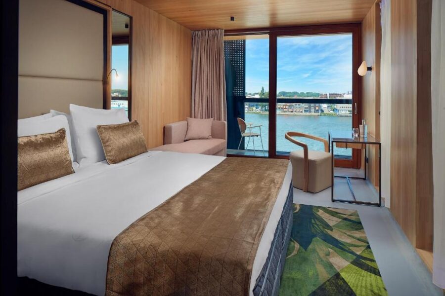 Interior of a hotel room at Hotel Jakarta Amsterdam, showcasing a beautiful river view from the window.