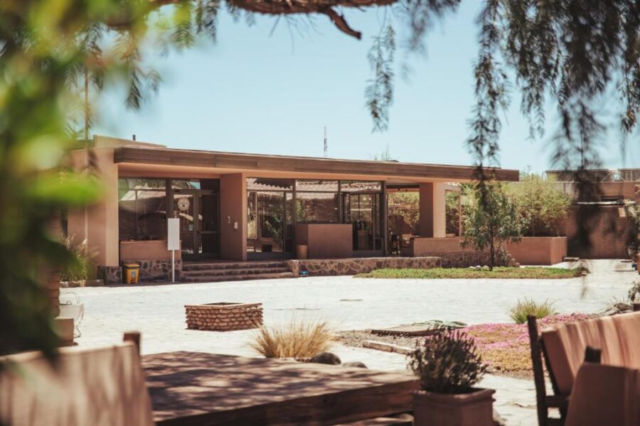 Hotel La Casa de Don Tomás features a house with a patio, surrounded by trees in San Pedro de Atacama, Chile.