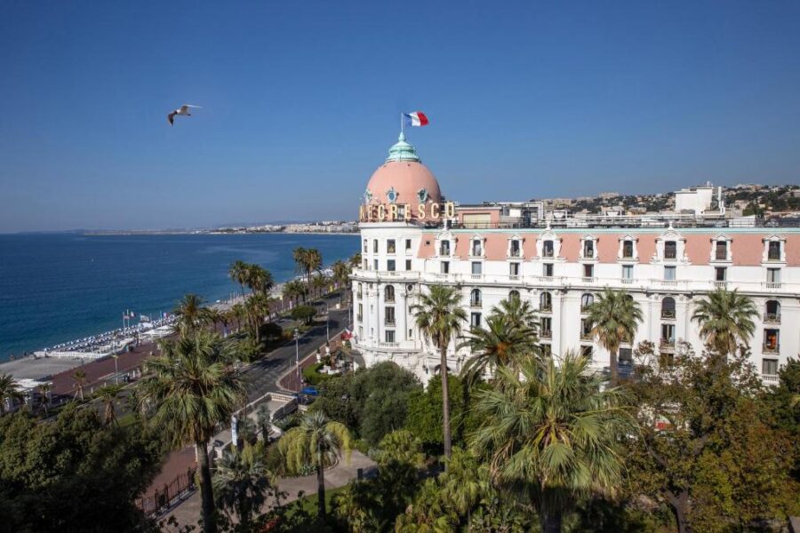 Hotel Le Negresco, a historic luxury hotel in Nice, France, features a pink dome and elegant architecture along the Promenade des Anglais.