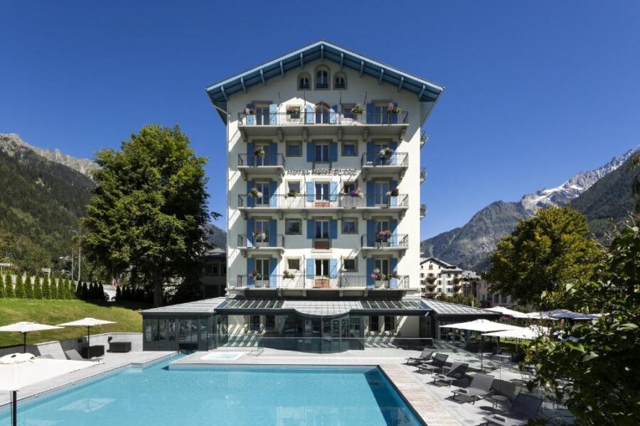 Exterior view of Hôtel Mont-Blanc Chamonix, France, featuring traditional alpine design and scenic mountain surroundings.
