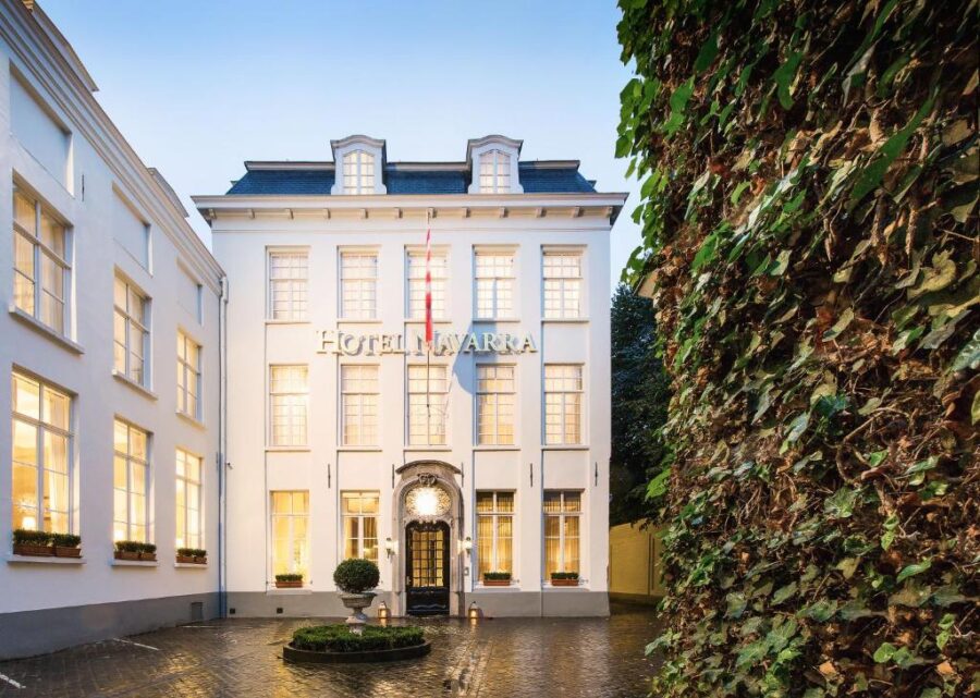 Hotel Navarra Brugge situated in a serene courtyard featuring a decorative fountain.