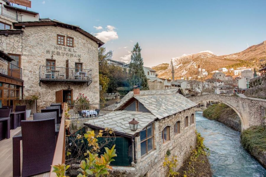 Scenic river divides a town, featuring Hotel-Restaurant Kriva Ćuprija in Bosnia and Herzegovina.