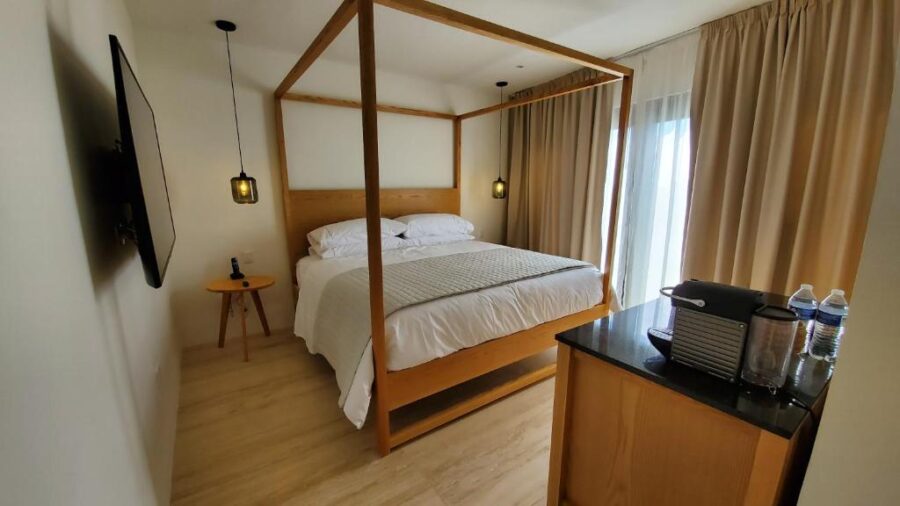 Interior of a hotel room at Hotel Secreto, showcasing a comfortable bed and inviting decor in Isla Mujeres, Mexico.
