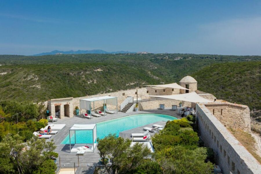The pool at Hotel Spa Genovese in France, enclosed by a rustic stone wall, offers a serene and private atmosphere.