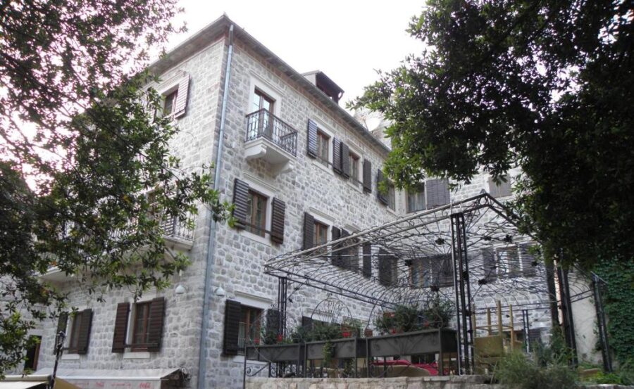 Exterior view of Hotel Villa Duomo, located in Old Town Kotor, Montenegro, featuring classic architecture and vibrant surroundings.