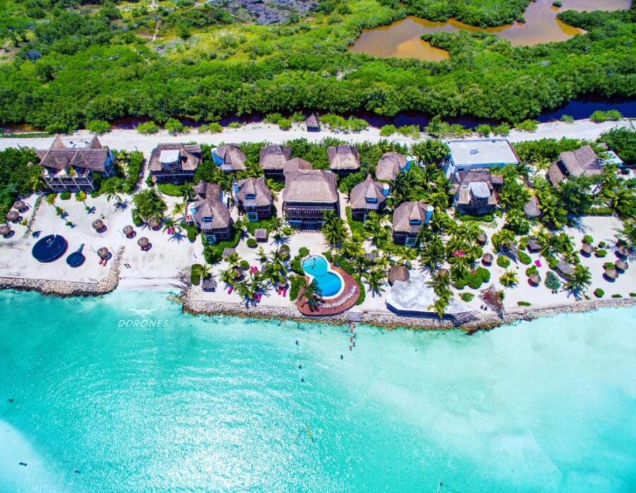 Aerial view of Hotel Villas Flamingos, a beach resort on Isla Hoblox, showcasing its proximity to the ocean and surrounding landscape.
