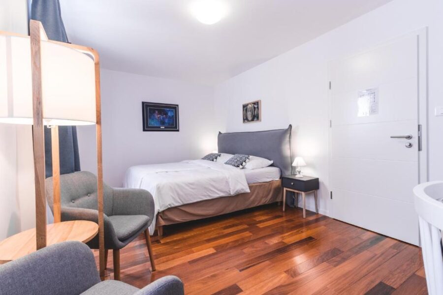 Interior of a hotel bedroom at Hotel Zala Piran, showcasing wooden floors and a comfortable bed.