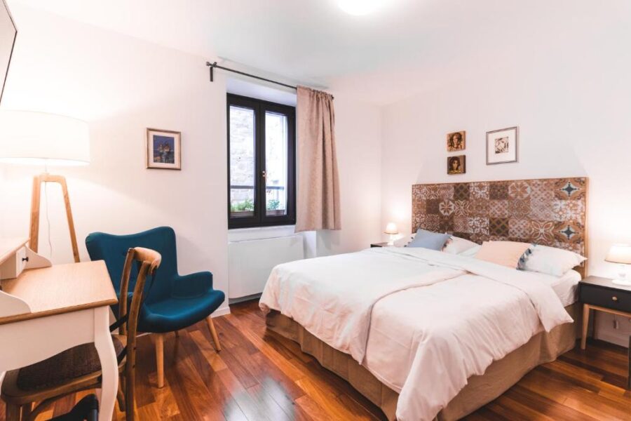 Interior of a hotel bedroom at Hotel Zala Piran, showcasing wooden floors and a comfortable bed.