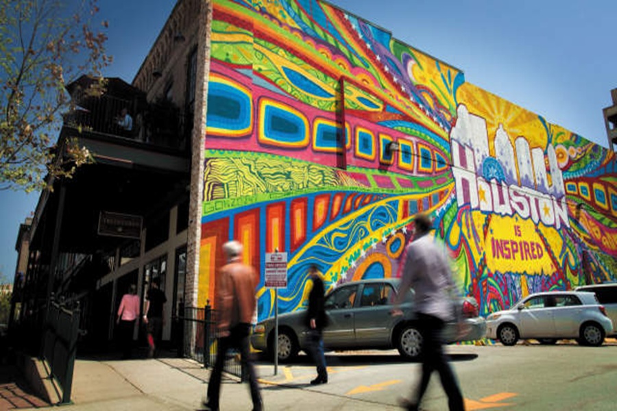 Vibrant Houston mural with bold colors, pedestrians, and lively urban atmosphere.