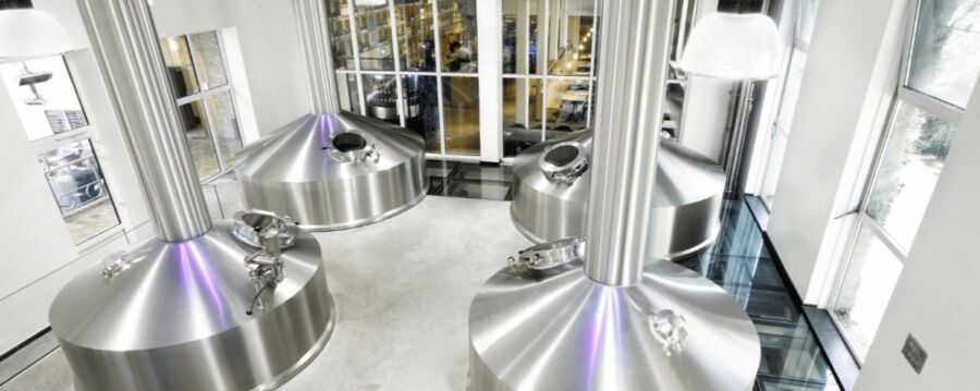 Interior view of Huisbrouwerij De Halve Maan featuring a prominent stainless steel tank used for brewing.