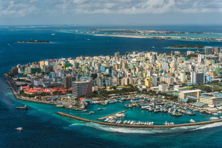 Aerial view of Hulhumalé, Maldives; modern cityscape and green areas surrounded by turquoise 