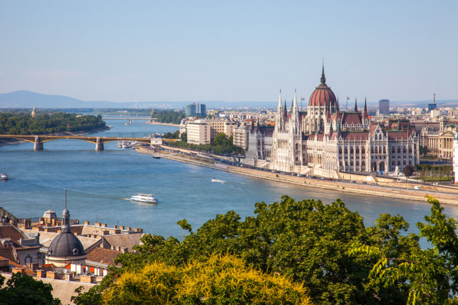 The Hungarian Parliament building stands proudly in Budapest, bathed in sunlight on a clear day, showcasing its grandeur
