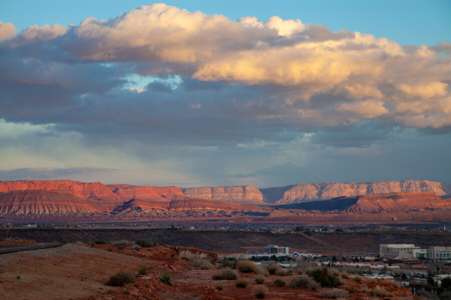 Dramatic clouds loom over the landscape of Hurricane, Utah, creating a moody and atmospheric scene.