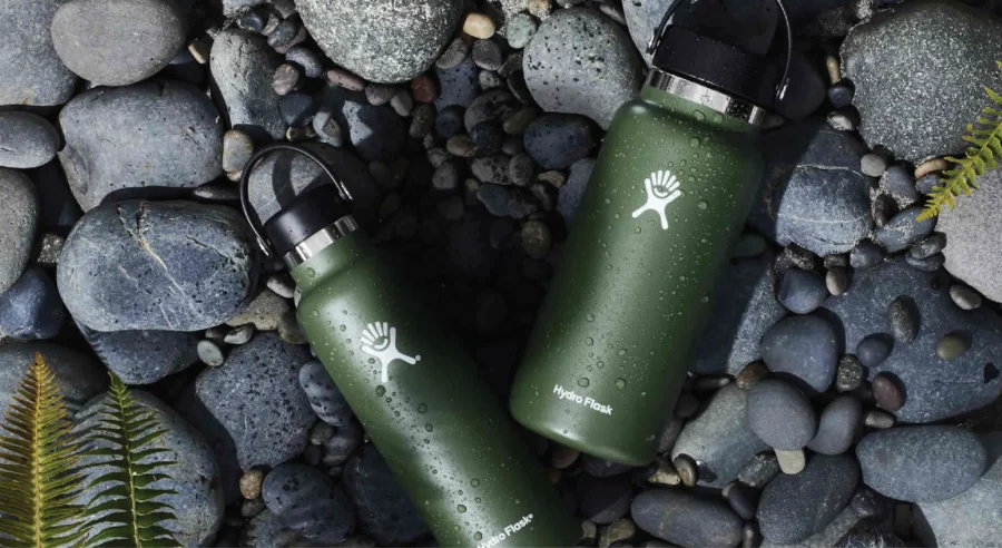 Stylish green Hydro Flask bottles on rocks, perfect for outdoor adventure and sustainability.