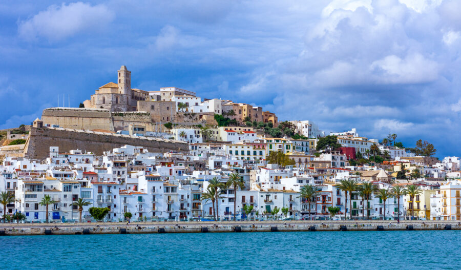 Panoramic view of Ibiza City showcasing vibrant buildings and the Mediterranean Sea under a clear blue sky