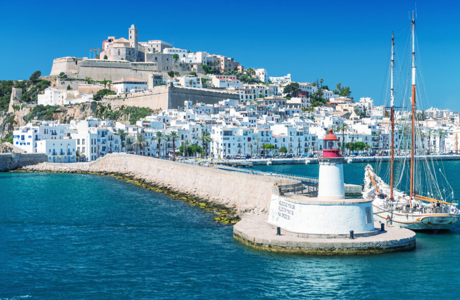Panoramic view of Ibiza port on a sunny day, showcasing the vibrant blue sea and picturesque island scenery