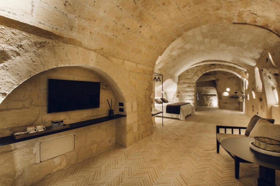 Interior view of Il Palazzotto I Residence & Winery in Matera, Italy, featuring a stone wall and a television.