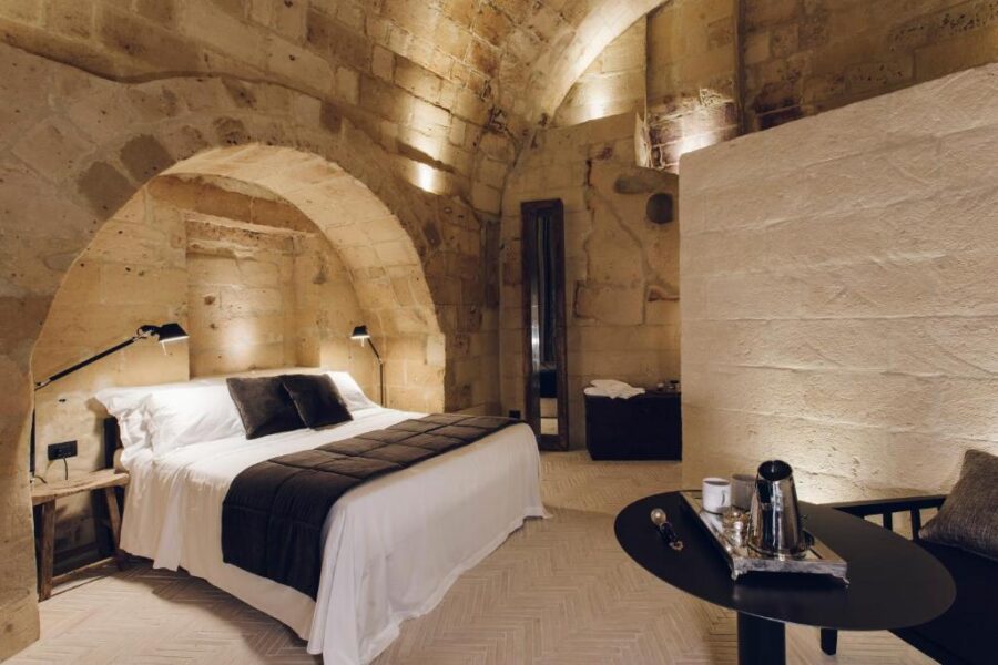 Charming bedroom with rustic stone walls and a bed, part of the Il Palazzotto I Residence & Winery.