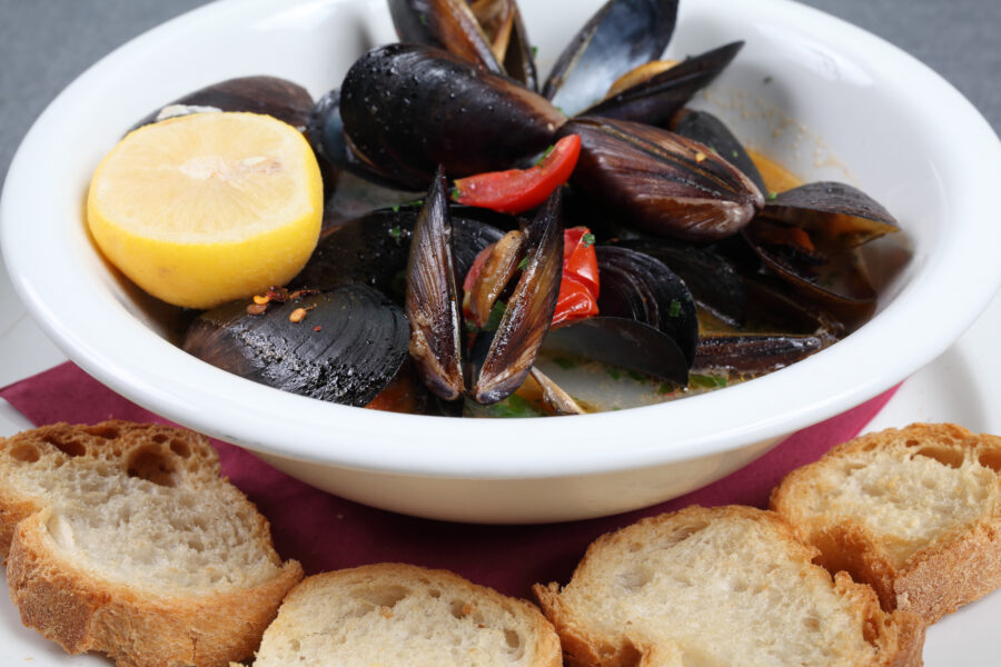 Close-up of Impepata di Cozze, showcasing mussels in a flavorful broth with herbs and spices