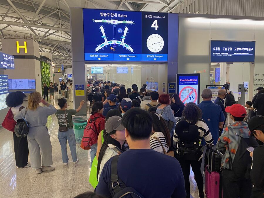 Passengers gather in a busy terminal at Incheon International Airport, eagerly awaiting their upcoming flights.