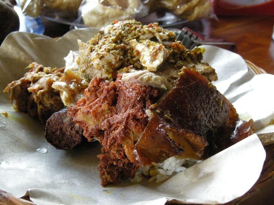 Indonesian Babi Guling: roasted pork, white rice, herbs, spices, banana leaf.