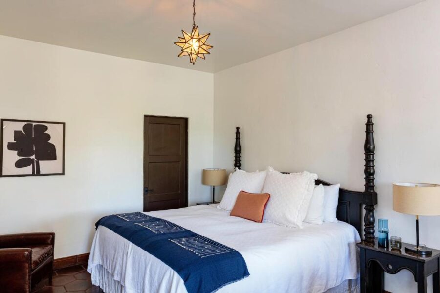 Elegant bedroom with a white bed adorned with a blue and white bedspread at Ingleside Estate Hotel & Bungalows.

