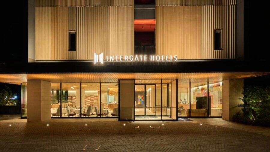 Night exterior of Intergate Hotels Kanazawa entrance with illuminated lobby, modern architecture, and warm lighting.