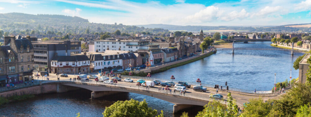 Scenic cityscape of Inverness, Scotland, highlighting the River Ness, charming streets, and surrounding natural landscapes.