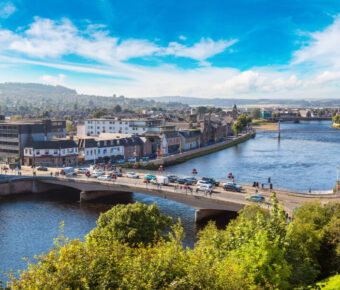 Scenic cityscape of Inverness, Scotland, highlighting the River Ness, charming streets, and surrounding natural landscapes.