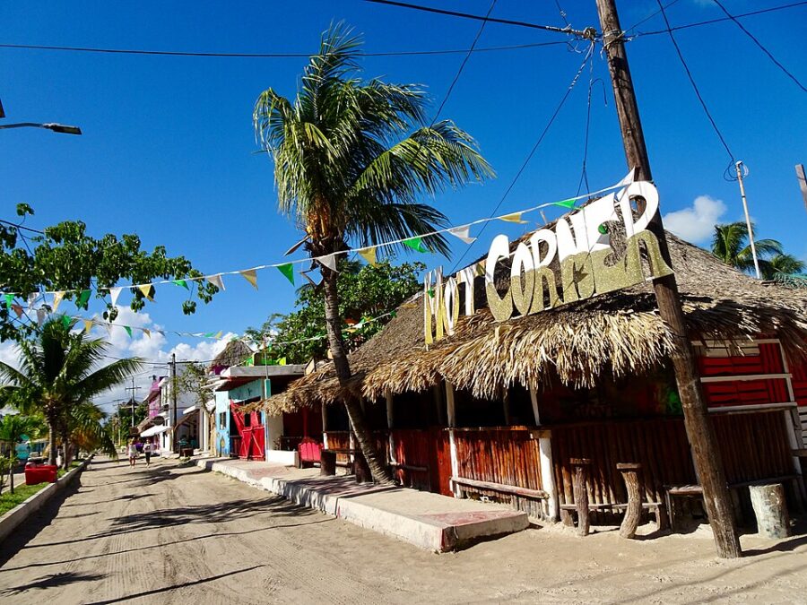 Street in Holbox Island, Mexico, featuring a sign that says "paradise," highlighting the island's tropical charm.