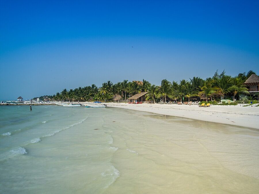 Picturesque view of Isla Holbox, showcasing white sandy shores and vibrant blue waters, perfect for relaxation.
