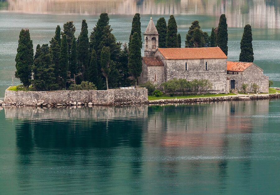St. George Island monastery in Perast, Bay of Kotor, Montenegro with cypresses and water reflections.