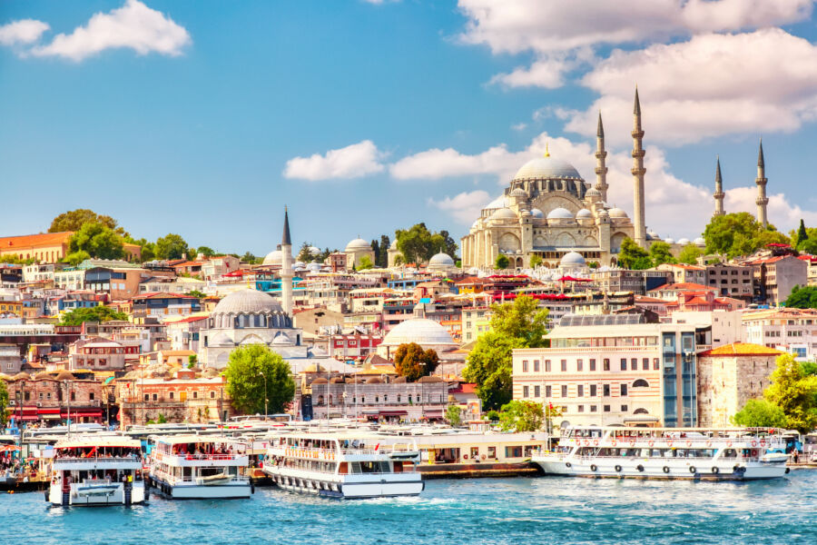 Touristic ships in Golden Horn bay, showcasing Suleymaniye Mosque and the skyline of Sultanahmet district in Istanbul