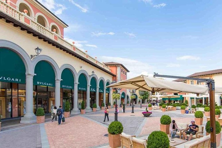 Bvlgari store in a neoclassical style Italian shopping district with elegant design and lush greenery.