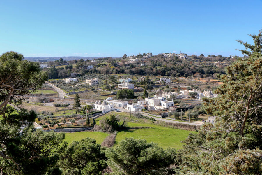 Panoramic view of the Itria Valley in Puglia, Italy, showcasing rolling hills and traditional trulli houses.