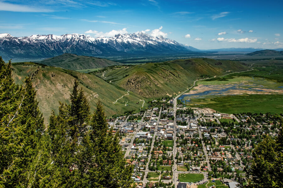 Aerial view of Jackson Hole, Wyoming, showcasing the town's layout surrounded by mountains and lush greenery