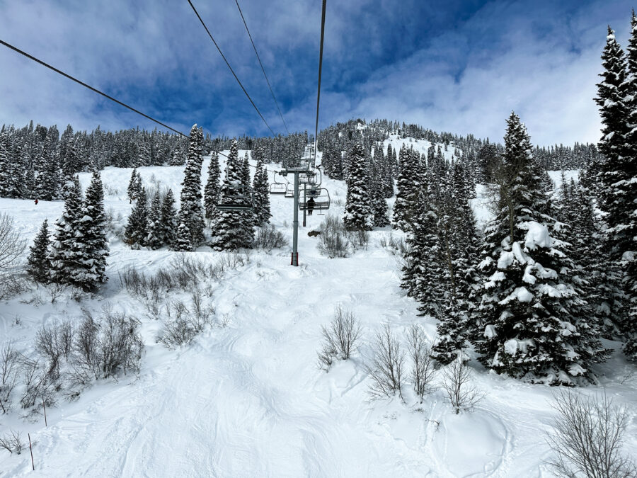 Snowy mountains in Jackson Hole, WY, with ski lifts ascending the slopes under a clear blue sky